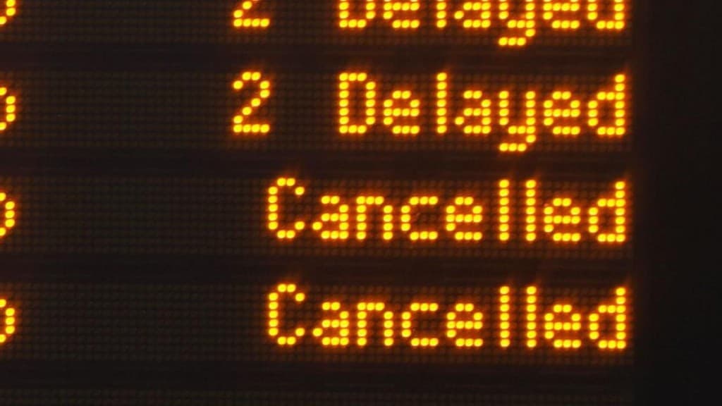 A station departure board showing delayed and cancelled trains, illustrating disrupted fan journeys home